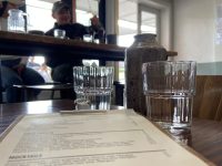 Hayes Common water glasses & menu with couple in background